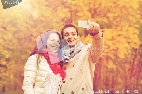 Image of smiling couple hugging in autumn park