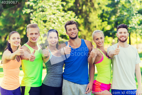 Image of group of happy sporty friends showing thumbs up