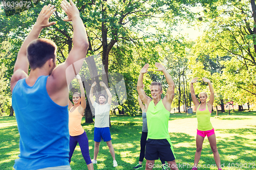 Image of group of friends or sportsmen exercising outdoors