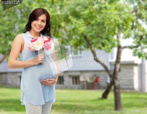 Image of happy pregnant woman with flowers touching belly