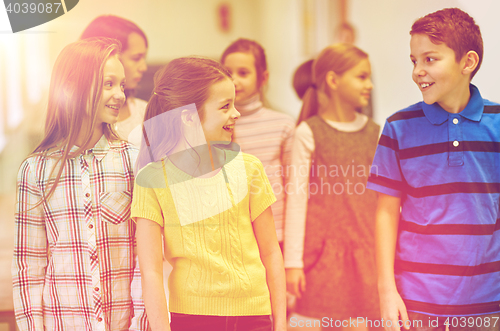 Image of group of smiling school kids walking in corridor