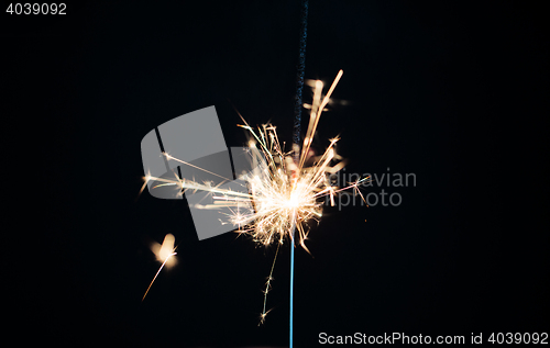Image of sparkler burning over black background