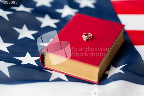 Image of close up of american flag, wedding rings and bible