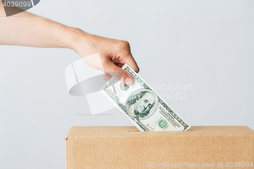 Image of man putting dollar money into donation box