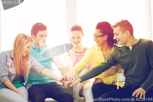 Image of smiling students with hands on top of each other