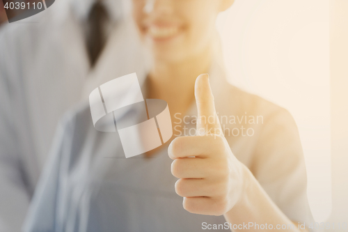 Image of close up of doctor or nurse showing thumbs 