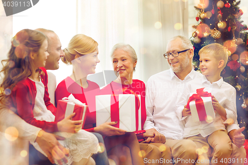 Image of smiling family with gifts at home