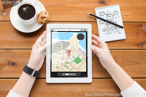 Image of close up of woman with tablet pc on wooden table