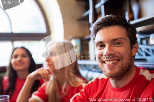 Image of fans or friends watching football at sport bar