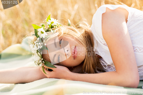 Image of happy woman in wreath of flowers on cereal field