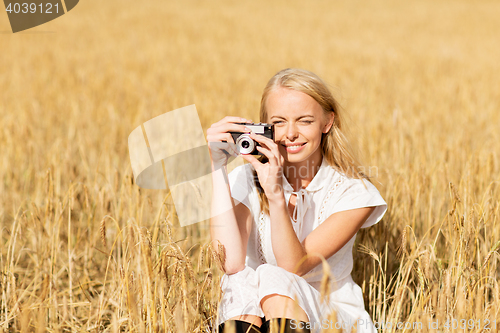 Image of happy woman with film camera in wreath of flowers