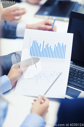 Image of close up of chats, laptop and graphs in office