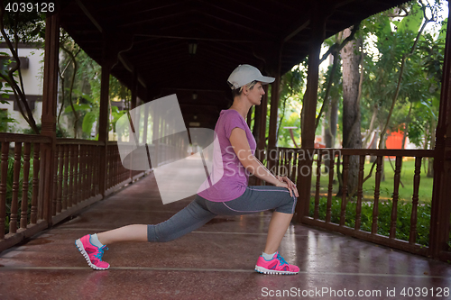 Image of woman  stretching before morning jogging