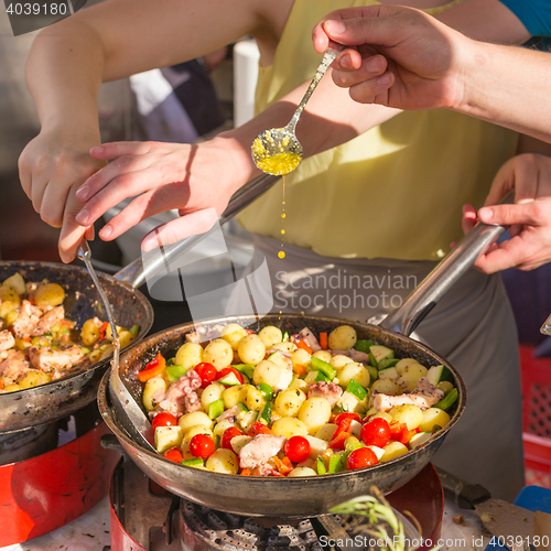 Image of Cheff cooking traditional Mediterranean octopus on street stall.