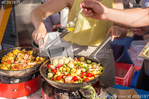 Image of Cheff cooking traditional Mediterranean octopus on street stall.