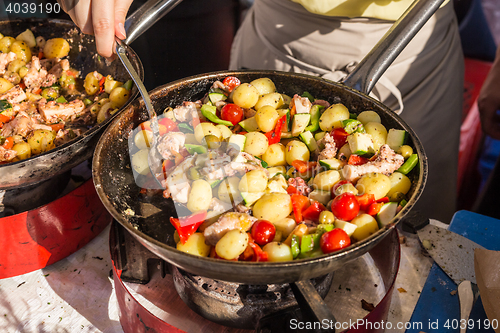 Image of Cheff cooking traditional Mediterranean octopus on street stall.