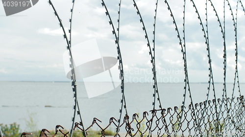 Image of Sea behind barbed wire fences