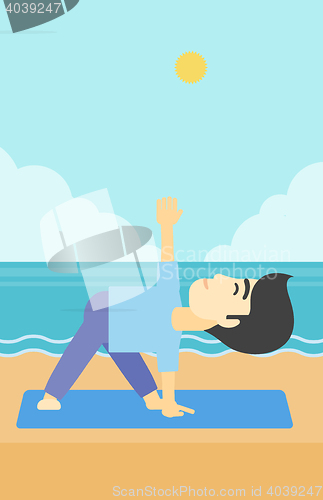 Image of Man practicing yoga triangle pose on the beach.