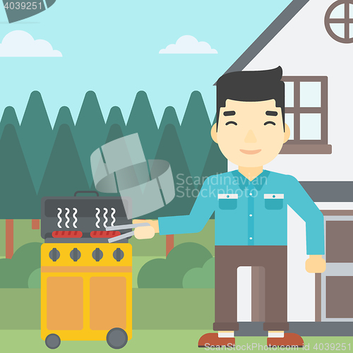 Image of Man cooking meat on gas barbecue grill.
