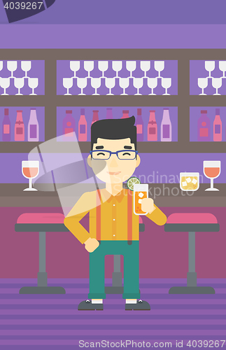 Image of Man drinking orange cocktail at the bar.