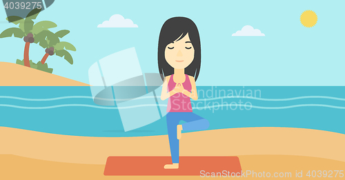 Image of Woman practicing yoga tree pose on the beach.