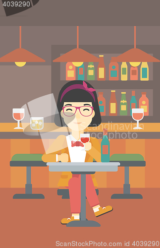 Image of Woman drinking wine at restaurant.