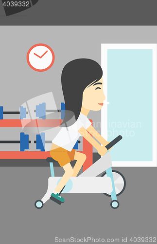 Image of Woman riding stationary bicycle.