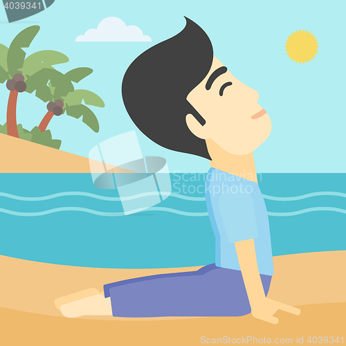 Image of Man practicing yoga upward dog pose on the beach.