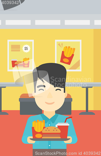 Image of Man with tray full of fast food.