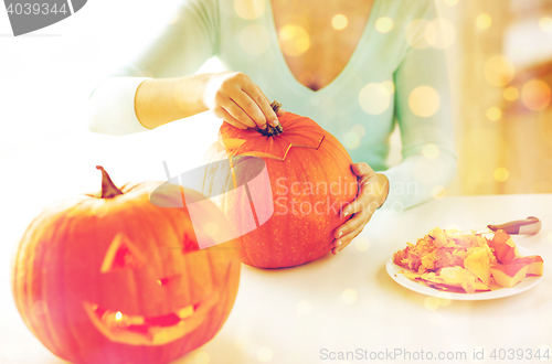 Image of close up of woman with pumpkins at home