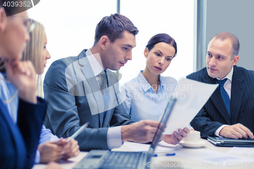 Image of business team with laptop having discussion