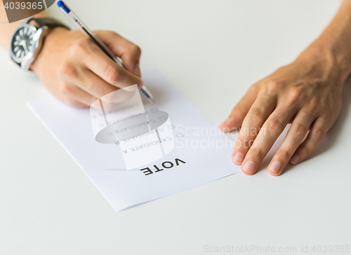 Image of close up of hands with vote or ballot on election