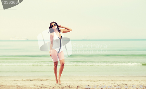 Image of young woman in swimsuit posing on beach