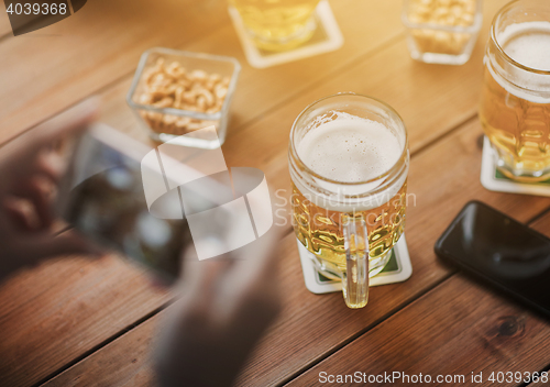 Image of close up of hands with smartphone picturing beer