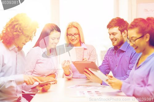 Image of smiling team with table pc and papers working