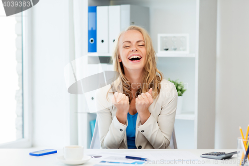 Image of happy businesswoman celebrating success at office