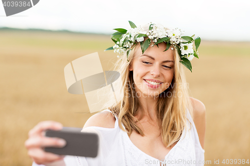 Image of happy young woman taking selfie by smartphone