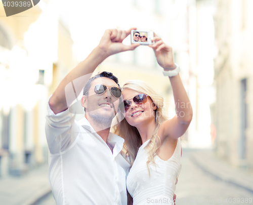 Image of travelling couple taking photo picture with camera