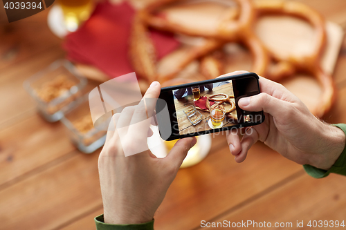 Image of close up of hands with smartphone picturing beer