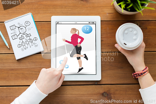Image of close up of woman with fitness app on tablet pc