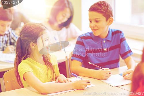 Image of group of school kids writing test in classroom