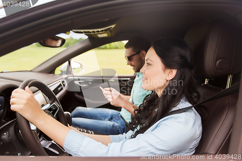 Image of happy man and woman driving in car