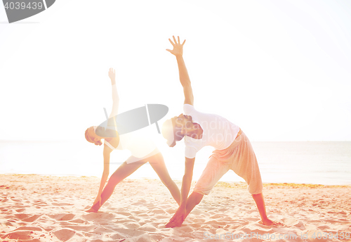 Image of couple making yoga exercises outdoors