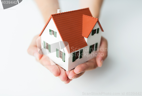 Image of close up of hands with house model