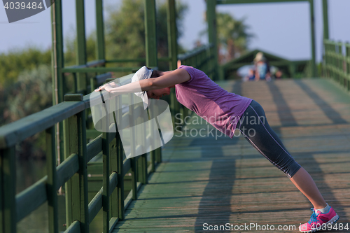 Image of woman  stretching before morning jogging