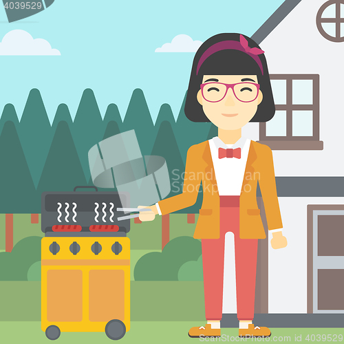 Image of Woman cooking meat on gas barbecue grill.