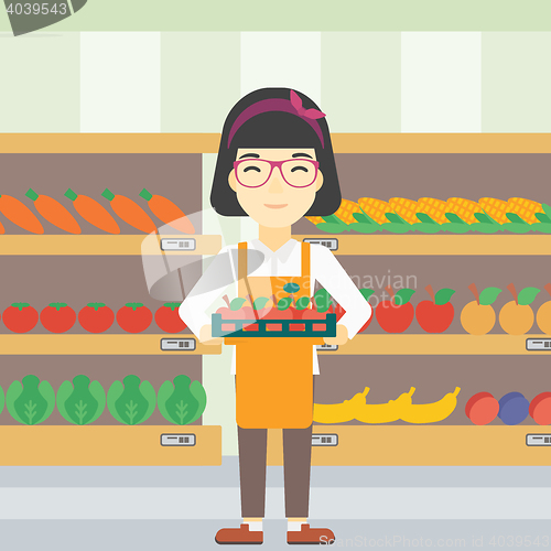 Image of Supermarket worker with box full of apples.