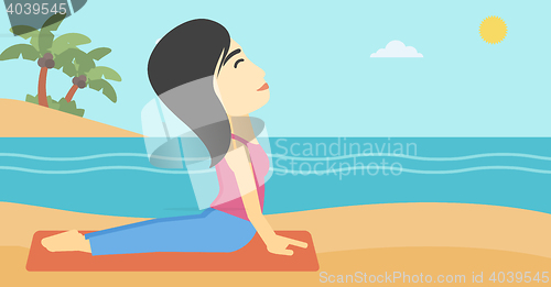 Image of Woman practicing yoga upward dog pose on beach.