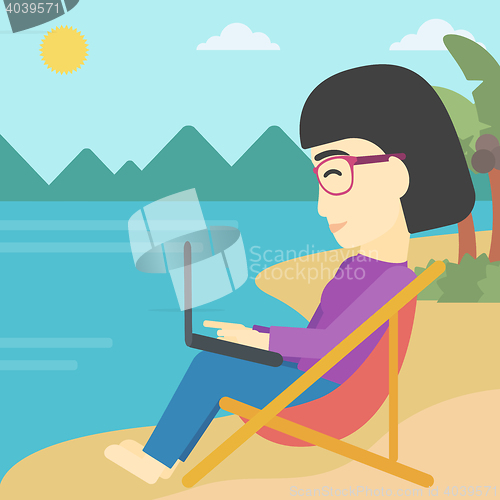 Image of Business woman working on laptop on the beach.