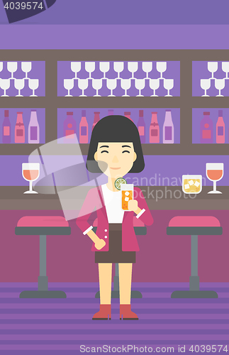 Image of Woman drinking orange cocktail at the bar.